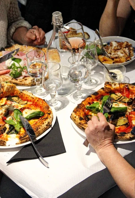 Pizzas partagées autour d'une table